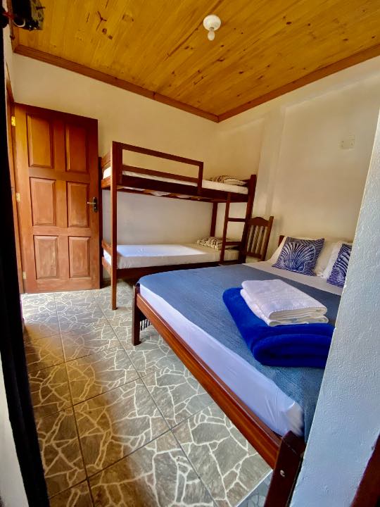 Quarto com beliche, cama e porta de madeira